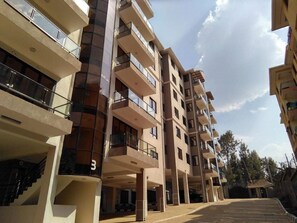 A multi-story residential building with balconies, a staircase, and a parking area. - Scenic View Thindigua Apartments (Nairobi)