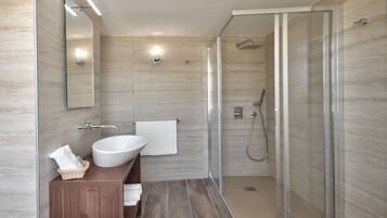 Une salle de bain moderne avec une douche à l’italienne, un grand lavabo et un meuble-lavabo en bois.