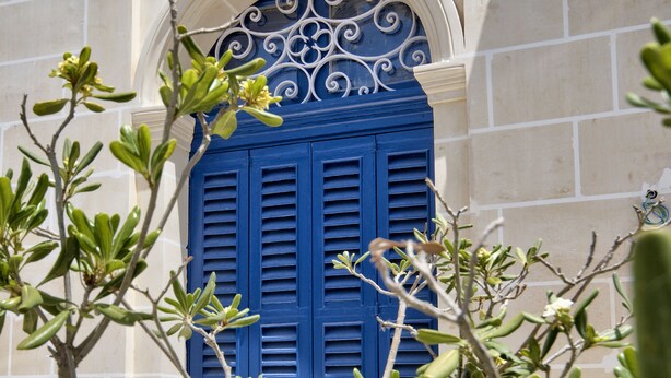 A building facade with a blue window framed by white architectural details. - The Suites - Piazza Kirkop (Kirkop)