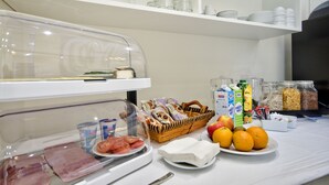 A breakfast buffet with various food items, including meats, fruits, and dairy products. - The Suites - Piazza Kirkop (Kirkop)
