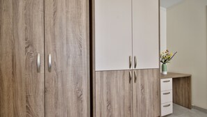 A wooden wardrobe with two doors and a small desk with drawers. - The Suites - Piazza Kirkop (Kirkop)