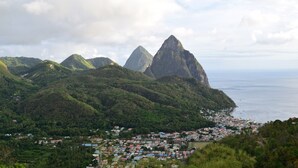 A coastal town with a prominent mountain peak in the background.