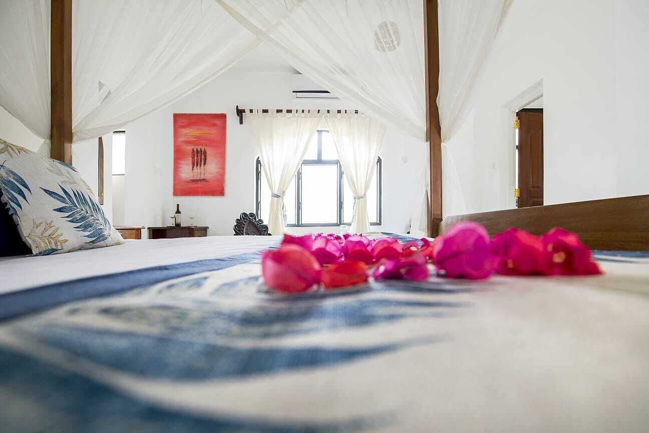 Un dormitorio con cama, ventana y un cuadro en la pared.