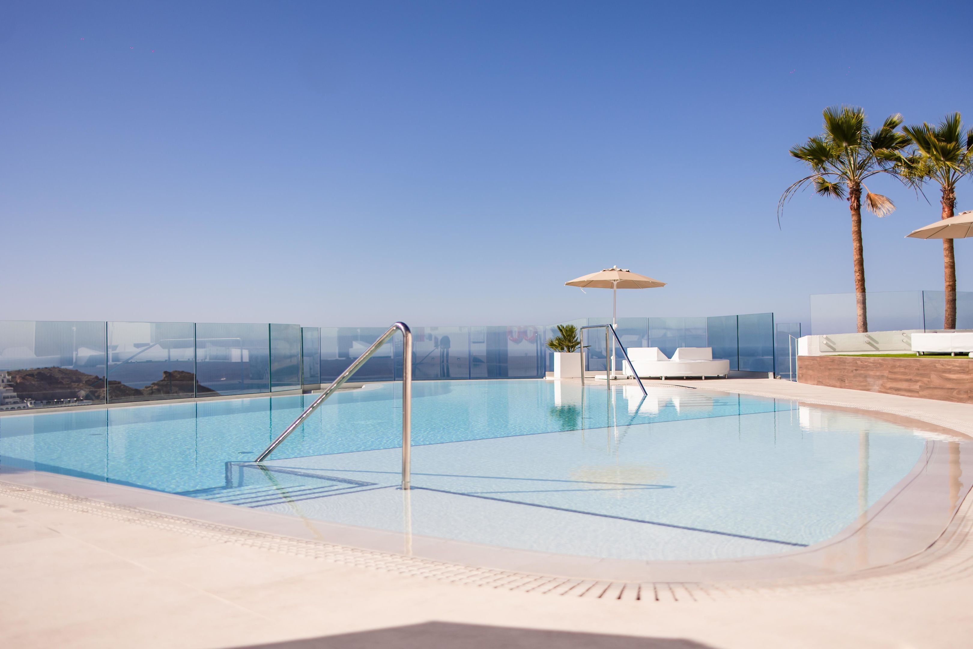 Una piscina al aire libre, sombrillas