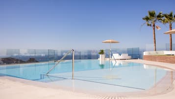 Una piscina al aire libre, sombrillas