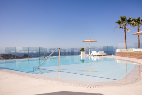 Una piscina al aire libre, sombrillas. Servatur Hartaguna - Adults Only