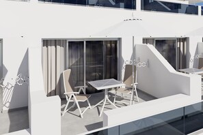 A modern outdoor seating area with white furniture and a glass partition. - Servatur Hartaguna - Adults Only (Mogan)