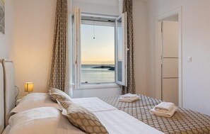 Enjoy a serene sea view from the large window, with a comfortable bed and a convenient table for your stay.