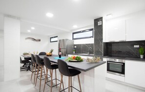 Enjoy cooking in this well-lit kitchen with an oven, refrigerator, and large island with bar stools.