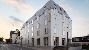 A modern hotel with a geometric facade, multiple windows, and a visible entrance. - Hotel Bergamo (Ludwigsburg)