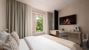 A hotel room with a bed, a desk with a chair, a television, and a window with curtains. - Hotel Bergamo (Ludwigsburg)