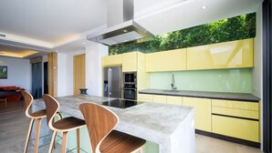 Eine moderne Küche mit einer zentralen Kochinsel, Barhocker und einer grünen Wand.