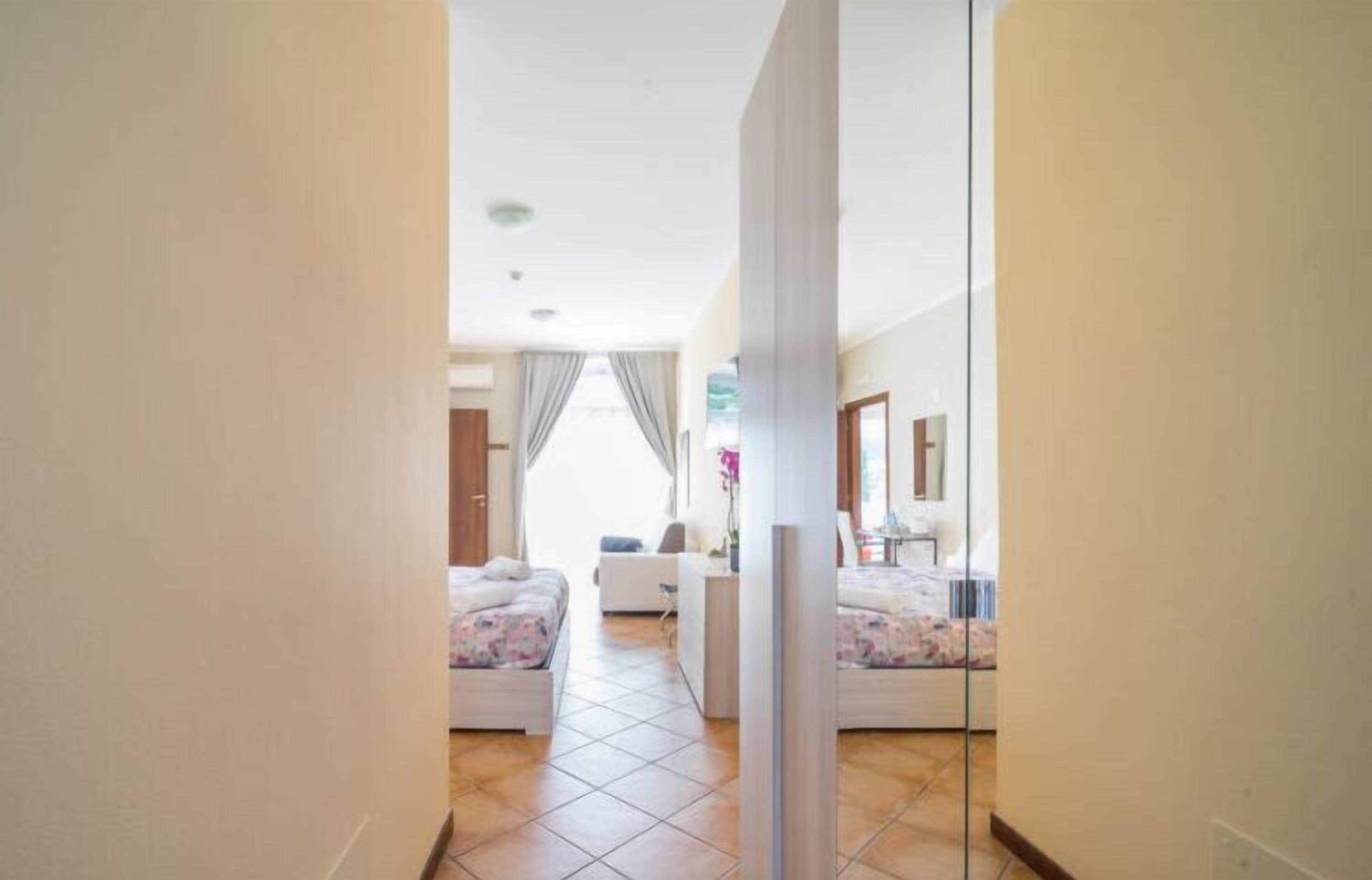 Habitación de hotel con dos camas, un escritorio y una silla.