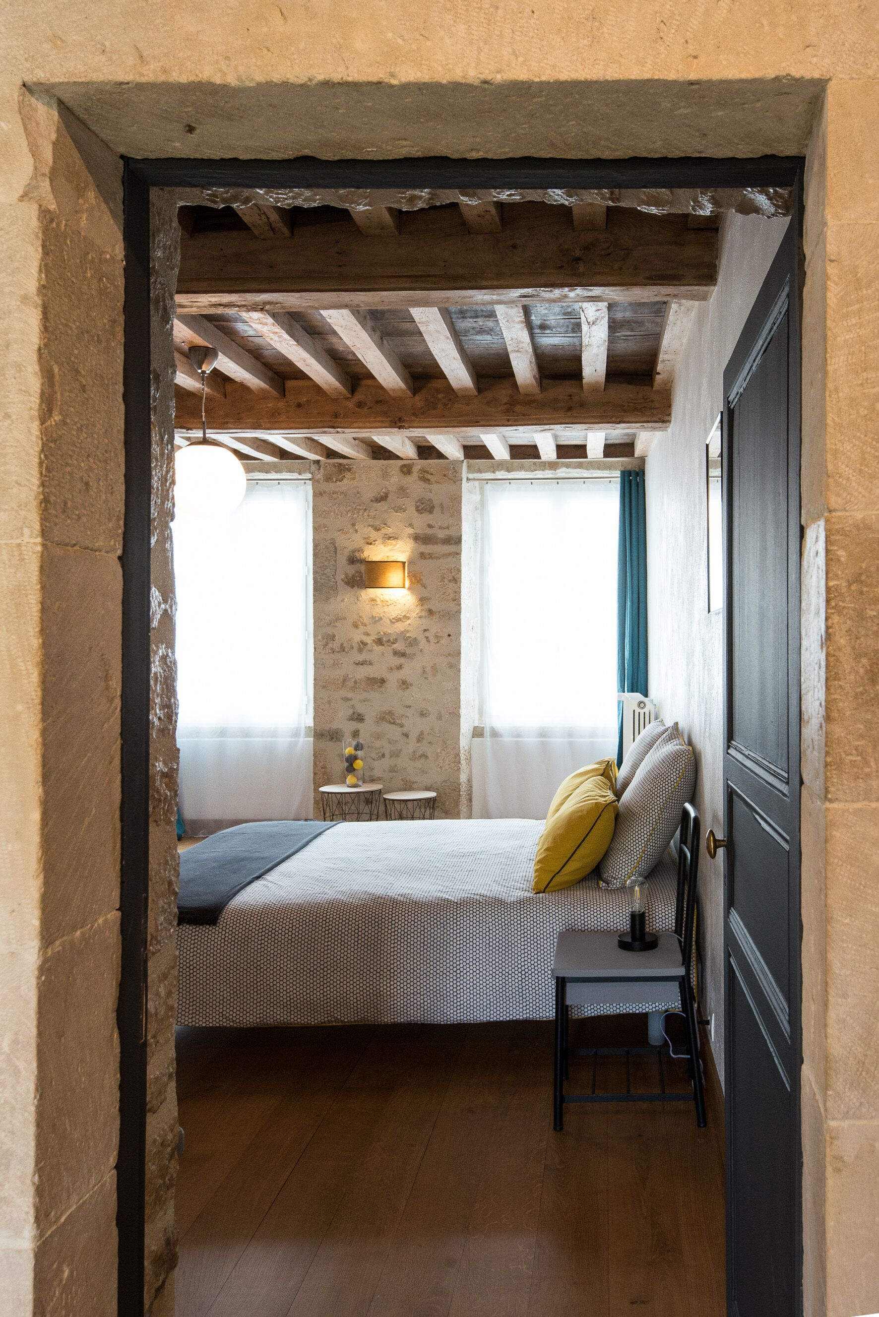 A bedroom with a bed, bedside table, and a lamp.