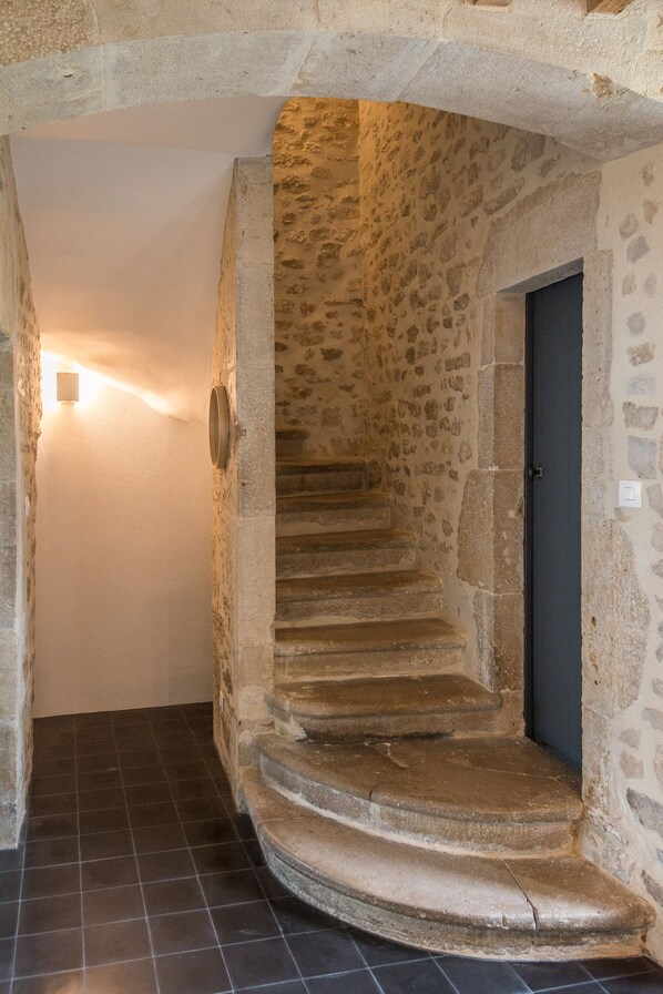 A stone staircase leading to a dark door, with a light fixture on the wall above. - Over time, Valognes, House of character (Valognes)