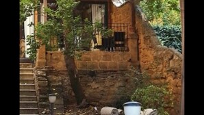 Un bâtiment en pierre avec un escalier en bois menant à un balcon.