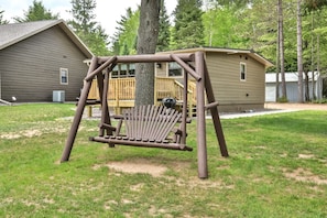 Relax in a serene backyard setting with a simple wooden swing.
