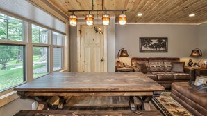 A rustic interior with a large wooden table, a sofa, and a bench.