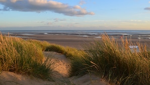 A beach with sand dunes and a clear sky.