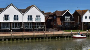 Une rangée de maisons blanches avec un quai et un bateau.