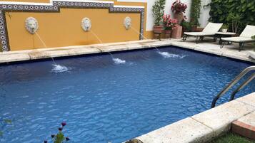 Een buitenzwembad en ligstoelen