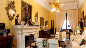 A traditional living room with a fireplace, ornate mirror, and classic furniture. - Casa San José (Palma del Rio)