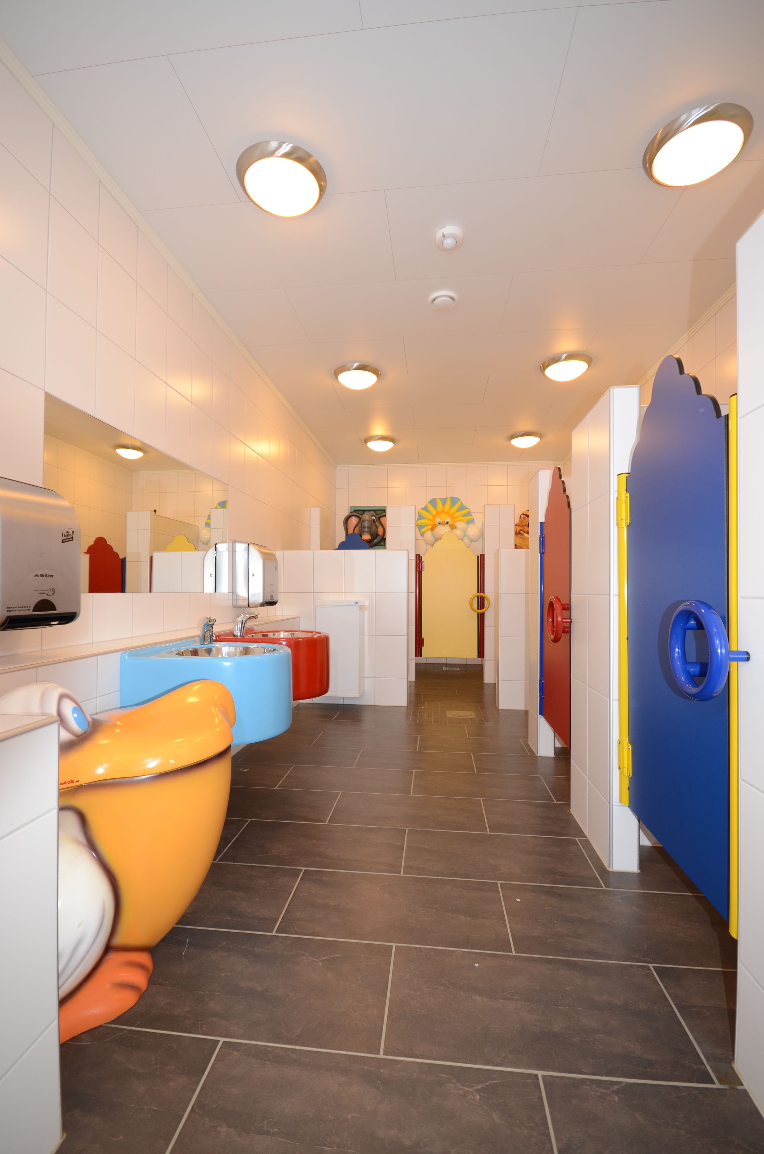 Un baño luminoso con diseño moderno, que incluye un lavamanos, espejo y un inodoro.