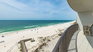A beach view from a balcony with a railing, a sandy beach, and a clear sky. - BEACH FRONT Three bedroom Condo 805 at Phoenix IX (Orange Beach)