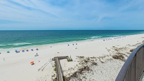 A beach with a wooden boardwalk, umbrellas, and a clear view of the ocean. - BEACH FRONT Three bedroom Condo 805 at Phoenix IX (Orange Beach)