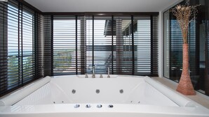 A modern bathroom with a large bathtub, black blinds, and a decorative vase. - Beautiful 3-Bedroom Villa at Surin Beach (Choeng Thale)