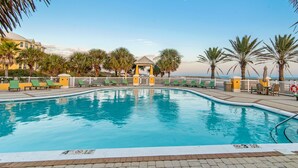 A swimming pool with a lifeguard stand, palm trees, and a view of the ocean. - 303W ~ Captivating 3BR/3BA condo with a Gulf view (Gulf Shores)