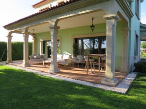 A covered patio with outdoor furniture, columns, and a pergola. - Casa da Agra, villa with pool and splendid garden (A Coru ña)