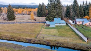Propiedad rural con casa principal, una construcción más pequeña y patio cercado.