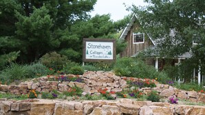 Een stenen muur met een bordje voor Stonehaven Cottages aan Tuscolia Lake LLC.