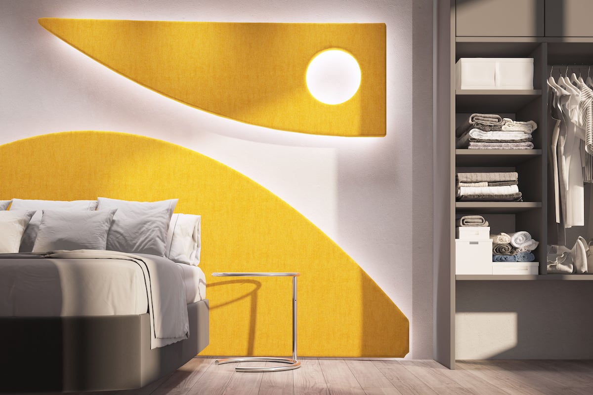 Un dormitorio moderno con cama, mesita de noche, armario e iluminación en la pared.