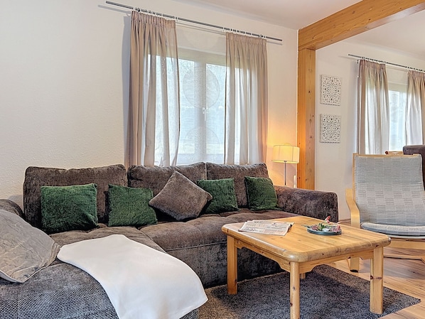 Un salon chaleureux avec un canapé, une table basse en bois et une lampe.