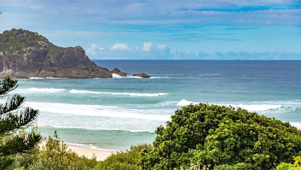 A coastal landscape with rocky cliffs and a beach.