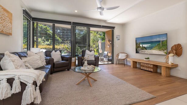 A modern living room with a sofa, coffee table, and a large TV. - Boom 8 - Boomerang Beach (Boomerang Beach)