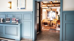 Ein Empfangsbereich mit einer blauen Tür, einer Karte an der Wand und einem Schild, das ein Restaurant anzeigt.