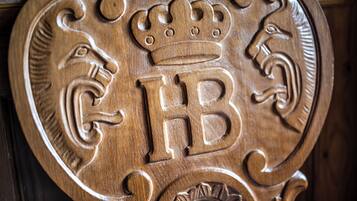 A wooden plaque with a crown, a lion, and the letters 'GB' carved into it.