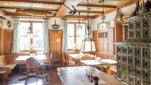 Ein rustikales Interieur mit einem Esstisch, Stühlen und einem Schrank.