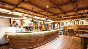 Eine Bar mit Holztresen, Barhocker und gefliestem Boden.