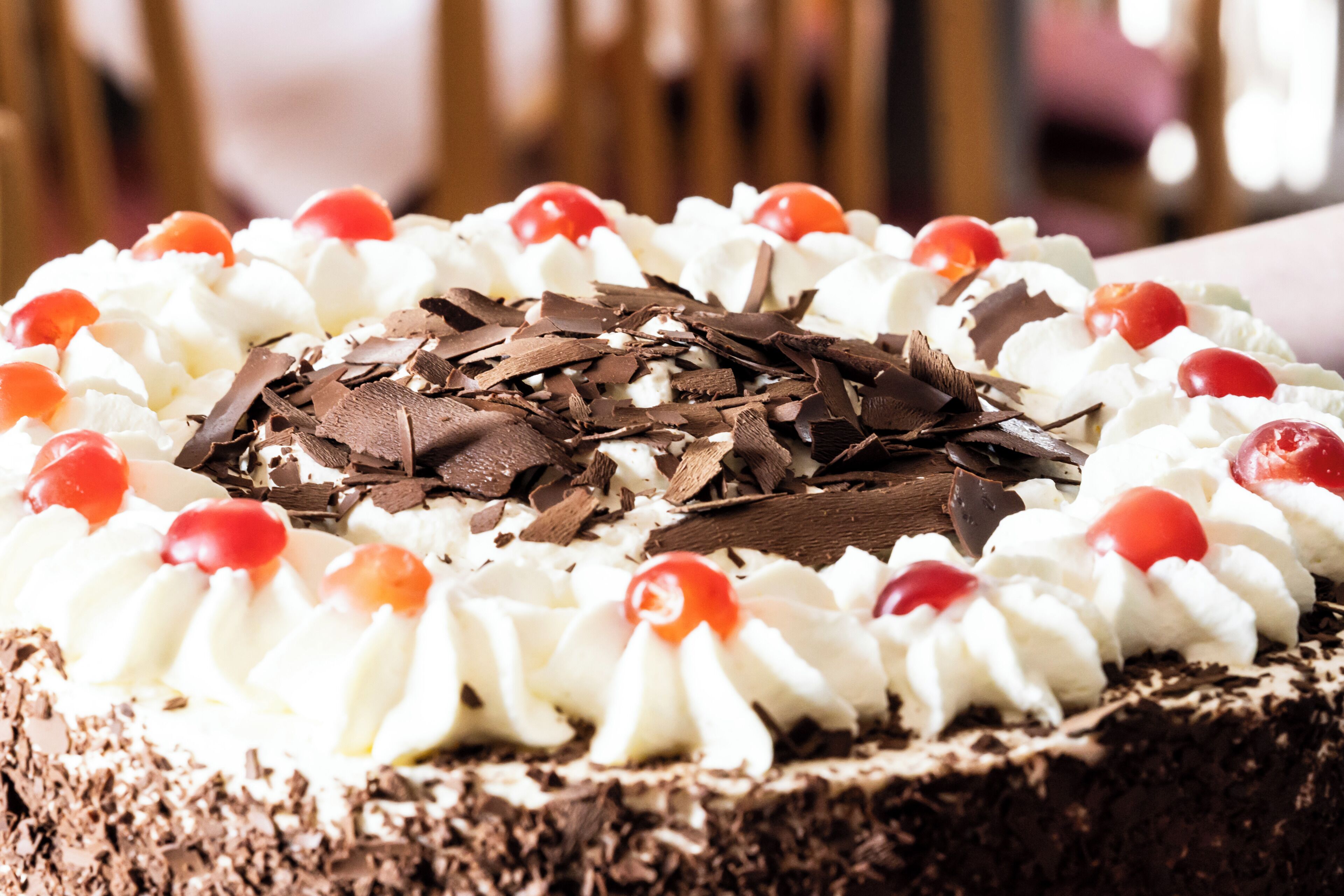 A chocolate cake with whipped cream and cherries.