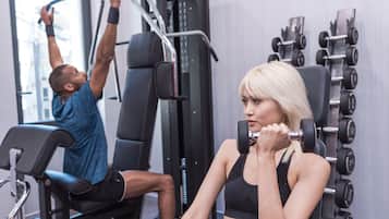 Une salle de sport équipée de matériel d'exercice, notamment un banc et des haltères.