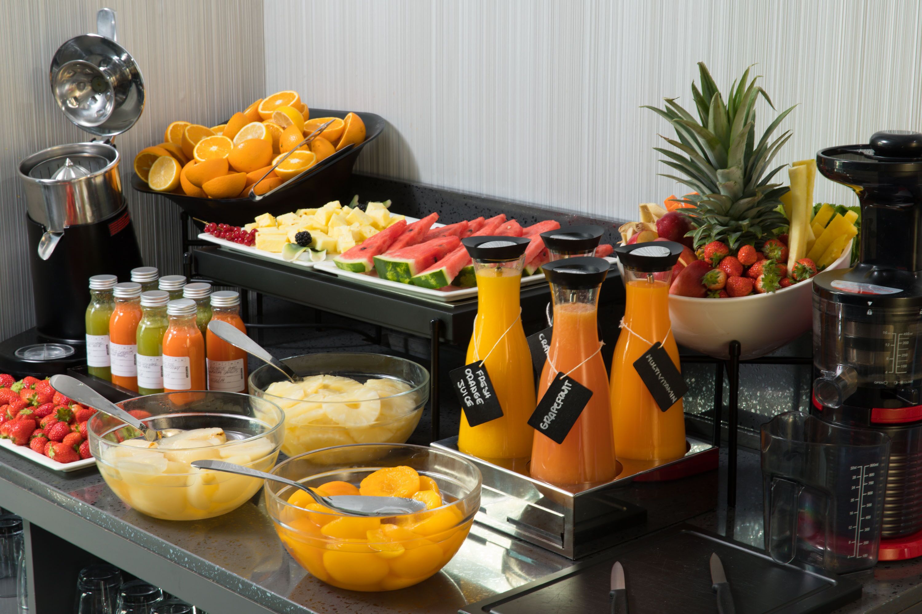 Un buffet con una varietà di frutta e succhi di frutta.