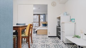 A compact living space with a dining area, kitchenette, and a bed with a view. - AFP Shimanouchi J Apartment (Osaka)