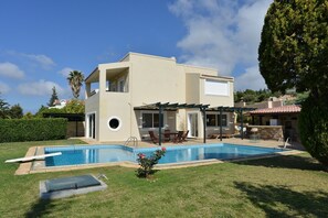 A two-story house with a swimming pool, a covered patio, and a stone fireplace. - Villa Xenia (Saronikos)