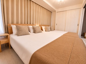 A hotel room with a large bed, wooden headboard, and a nightstand.