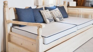 A wooden bed with a mattress, pillows, and a wooden headboard.