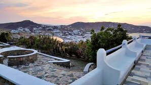A coastal view with white buildings, a stone pathway, and a white railing.